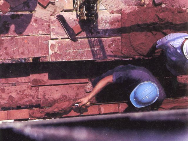A worker lays bricks during construction of Management Hall
