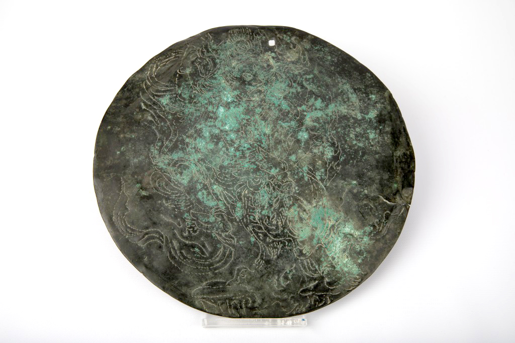 Image of a circular bronze mirror incised with an image of the Buddhist deity Zaō Gongen. 