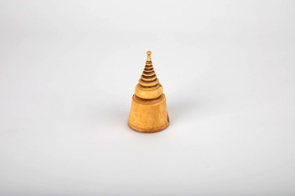 An ivory object in the form of a Southeast Asian stupa that is spire-like in shape.